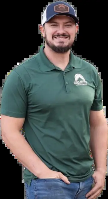 James King, founder and owner of Clear Cutters Tree Service, in a green company polo and cap